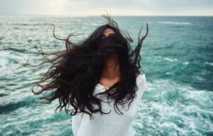 אישה נהנית איך הרוח מעיפה את שערה הארוך